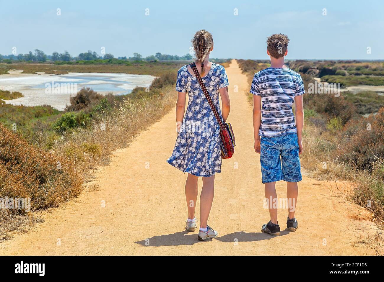 Woman  and boy hiking on sandy path in portuguese coastal area Stock Photo