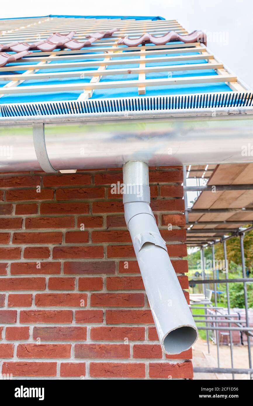 Roof of new dutch house with gutter and plastic pipe Stock Photo