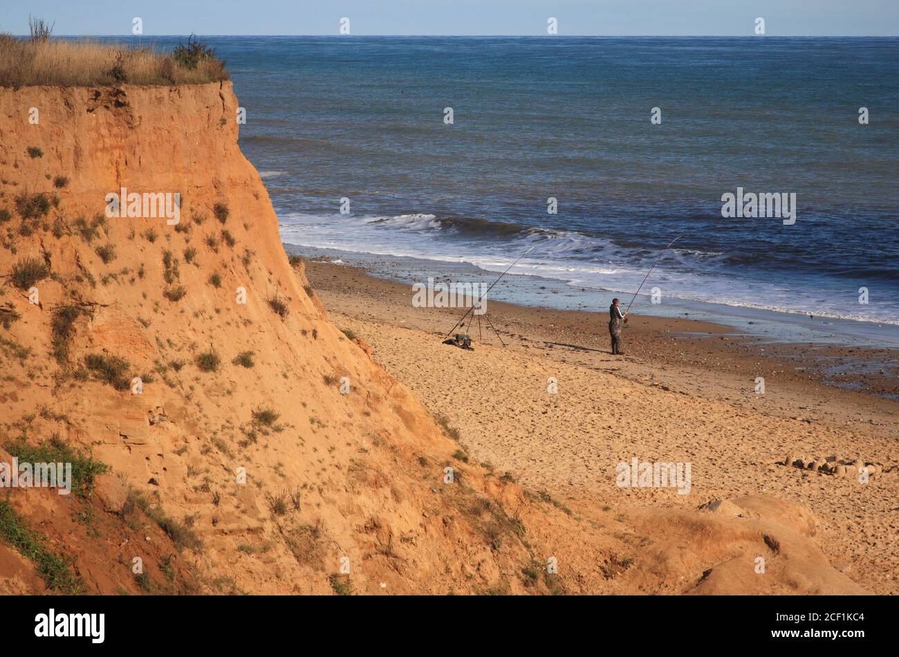 A sea angler fishing from the beach on the North Norfolk coast at ...