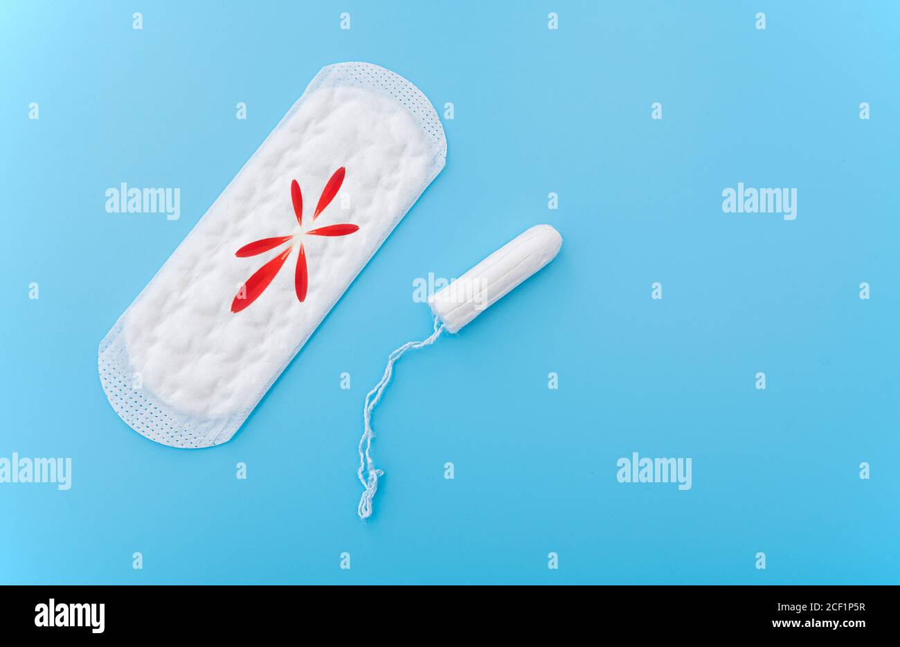 Sanitary napkin and menstruation tampon on blue background, concept picture about women's menstruation cycle, top view Stock Photo