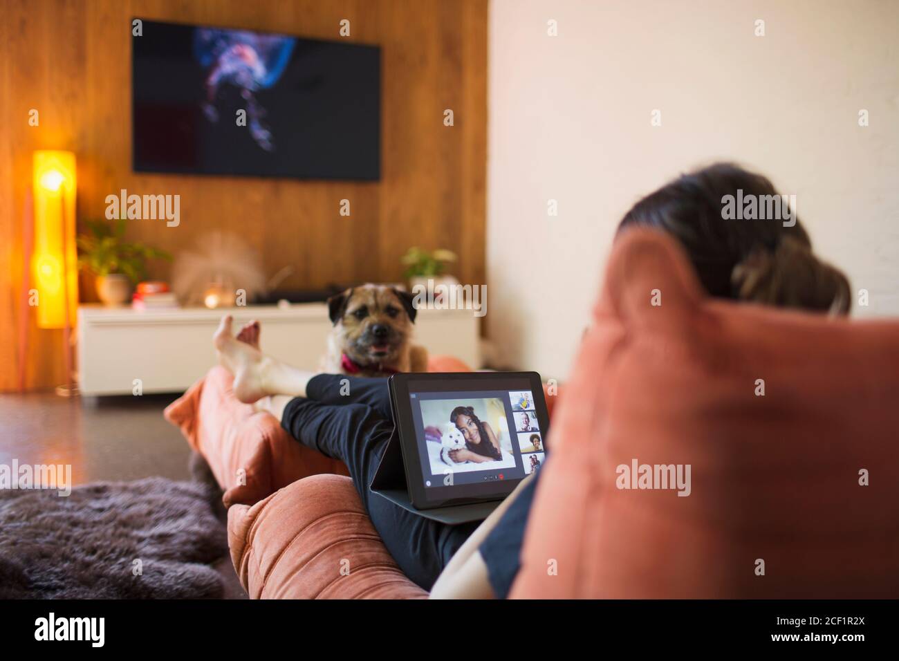 Woman with dog video chatting with friends on digital tablet screen Stock Photo