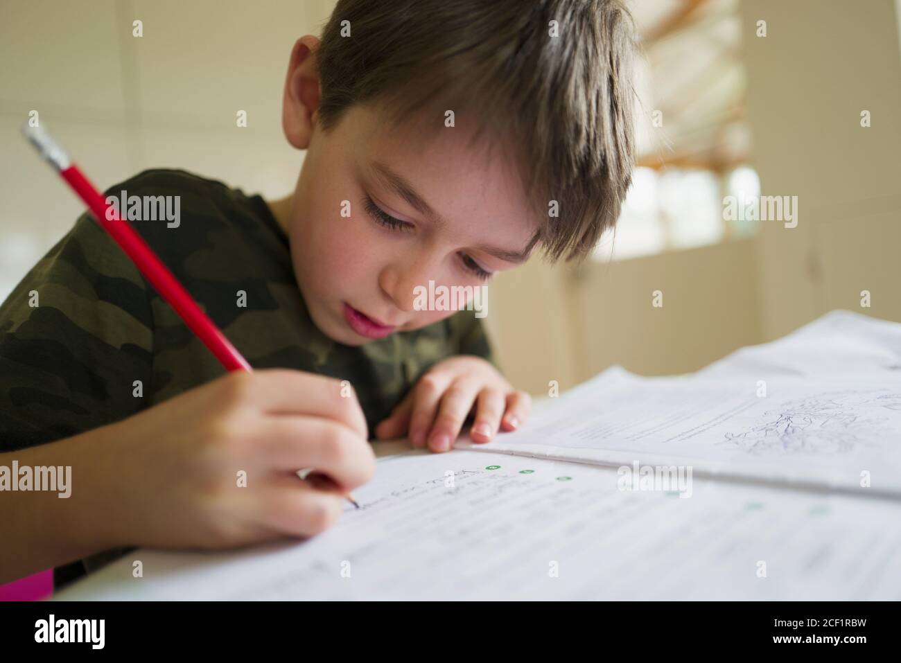 Close up focused boy home schooling Stock Photo