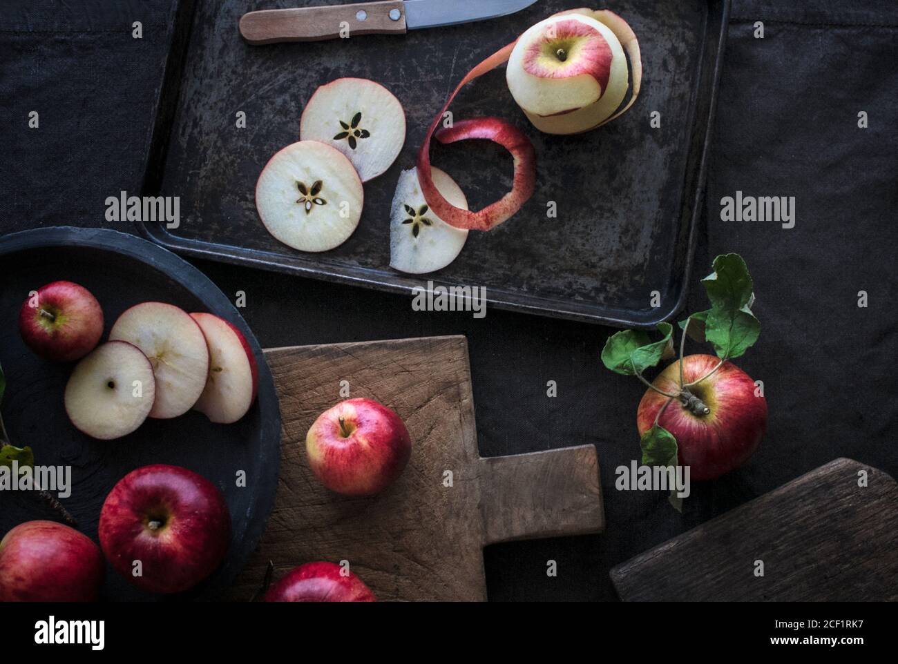 Fresh red apple slices on cutting board and sheet pan Stock Photo