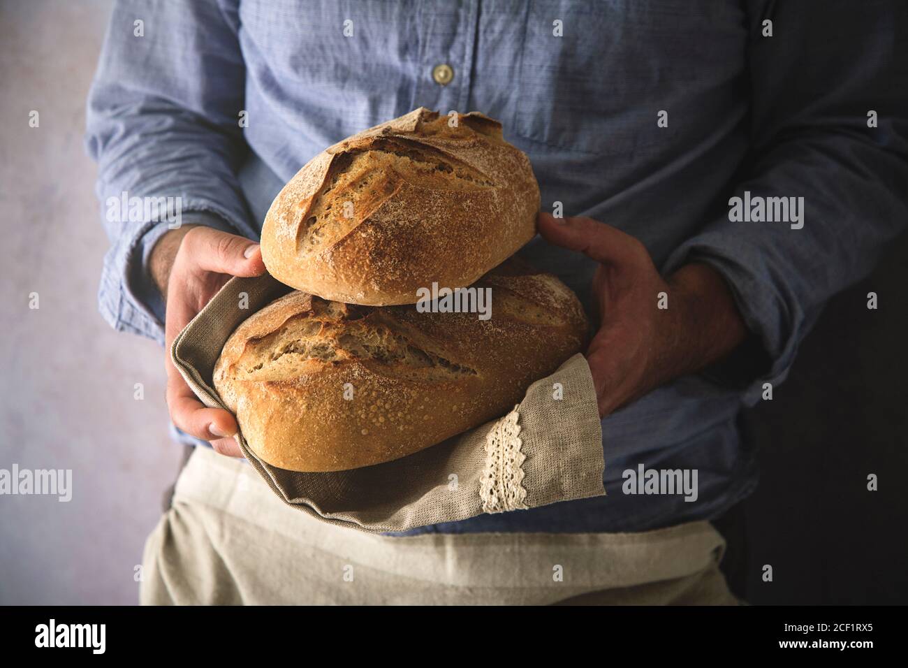 Close up man holding fresh home baked sourdough bread loaves Stock Photo