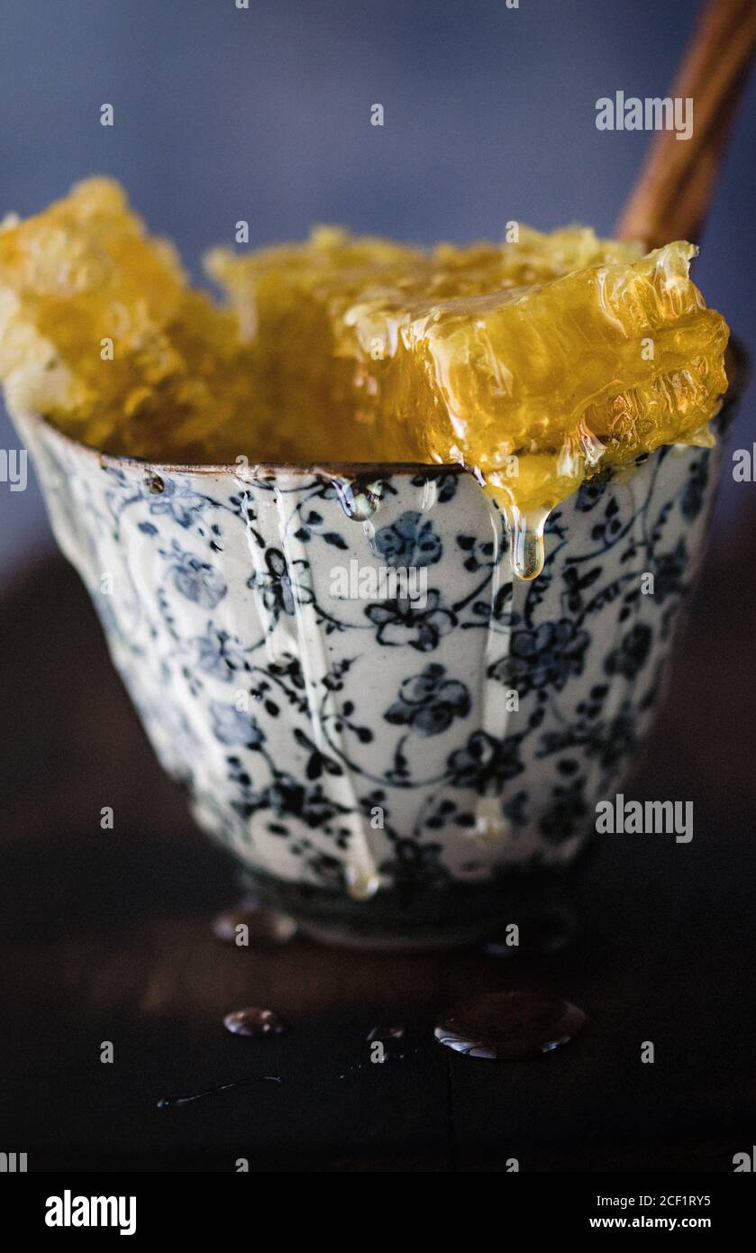 Close up dripping honeycomb in bowl Stock Photo