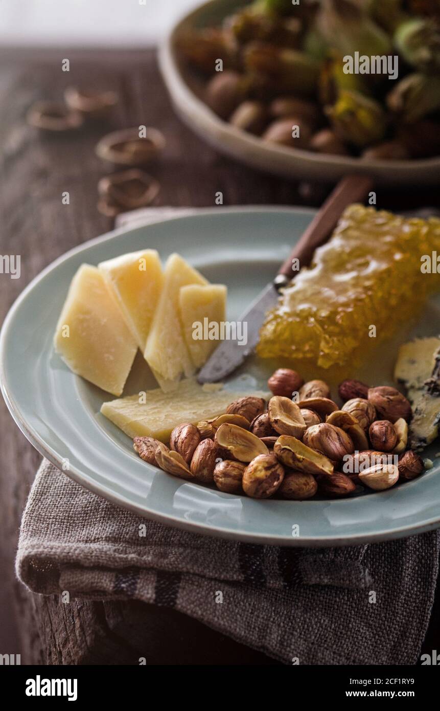 Cheese platter with honeycomb and hazelnuts Stock Photo