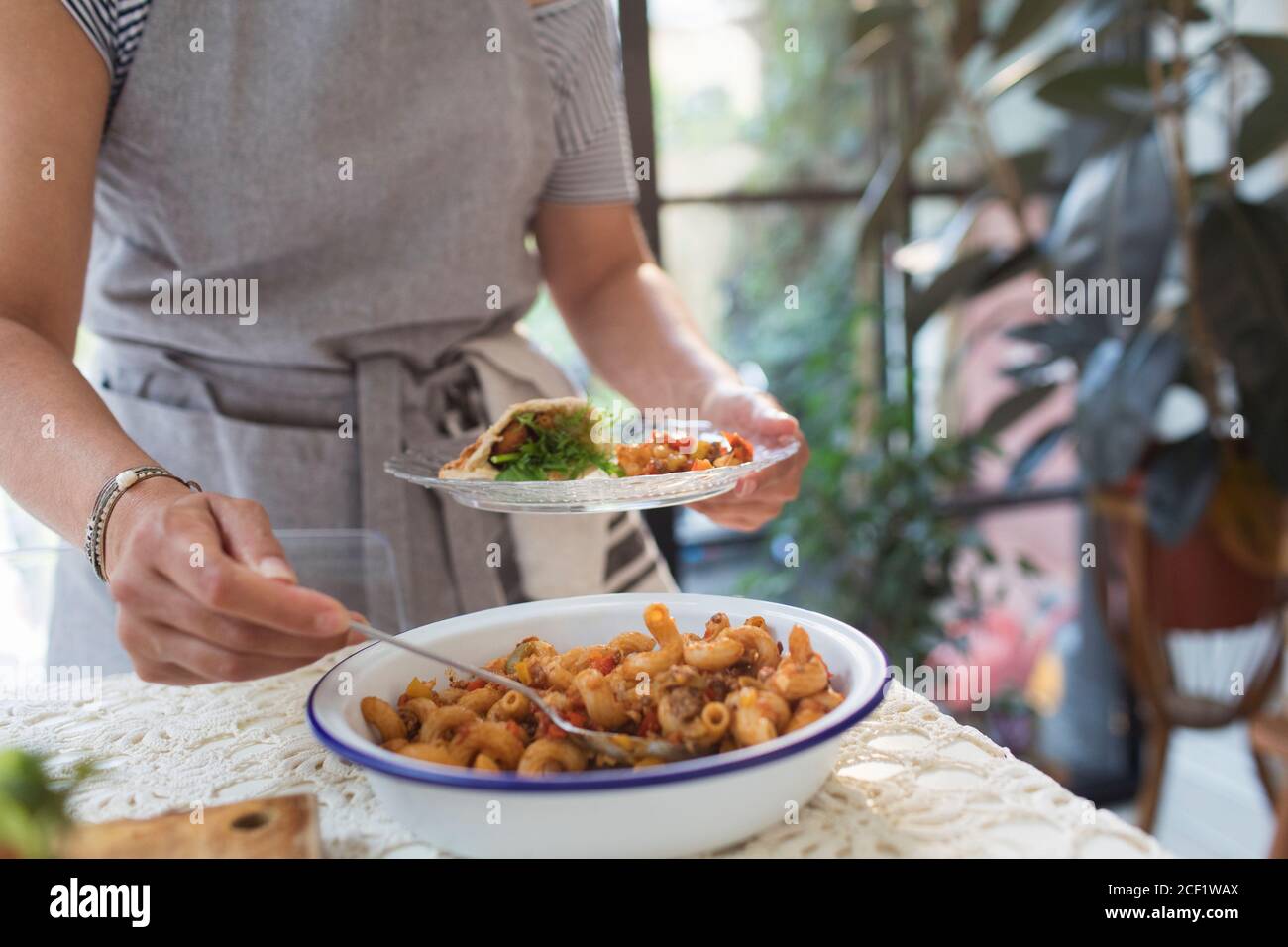 Woman serving pasta dish Stock Photo