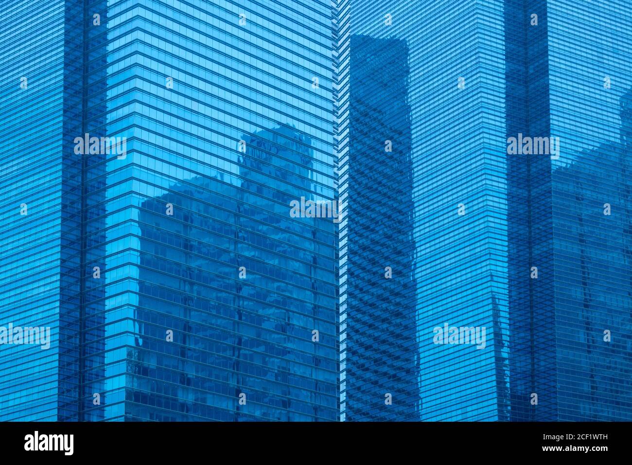 A multi-storey skyscraper with glass facades and reflection of another skyscraper. Stock Photo