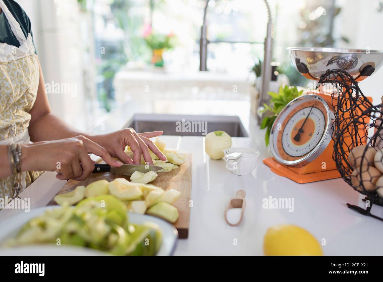Woman slicing apples for baking in kitchen Stock Photo