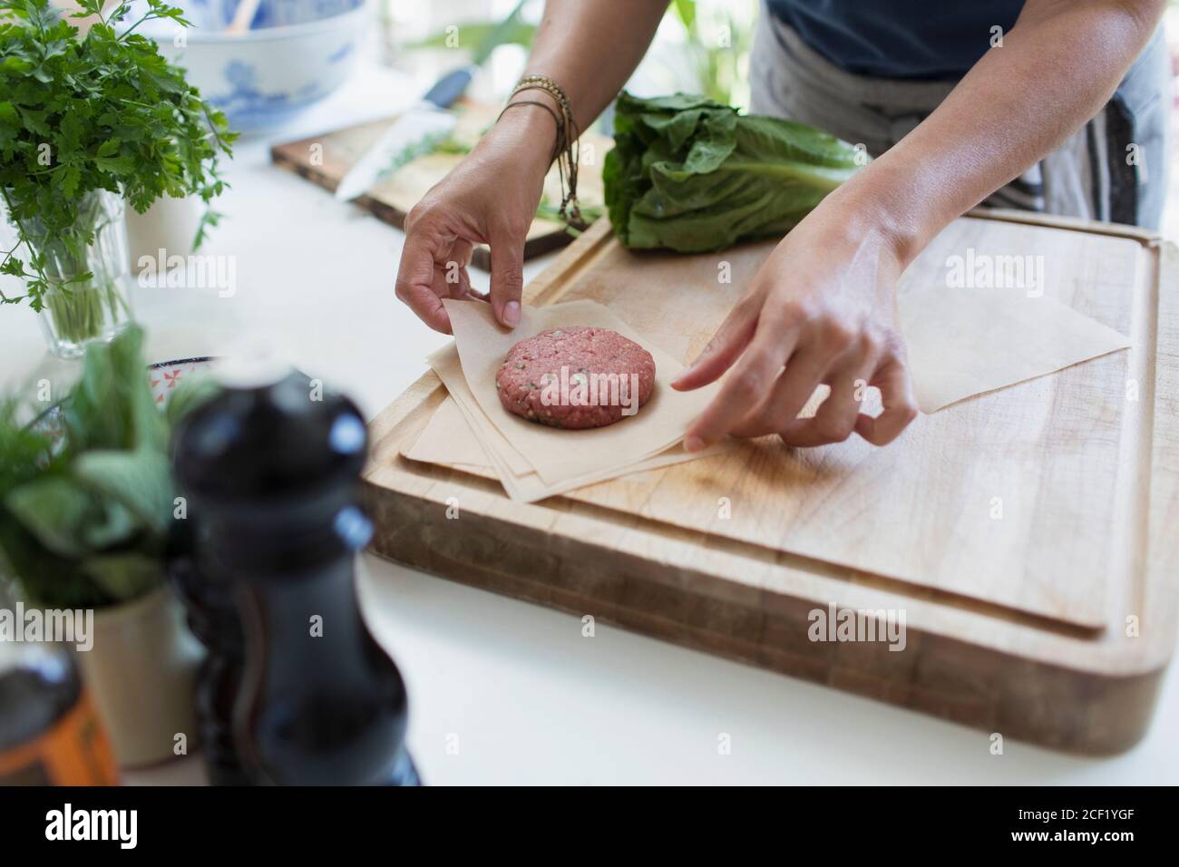 Woman making fresh hamburger patties on cutting board Stock Photo