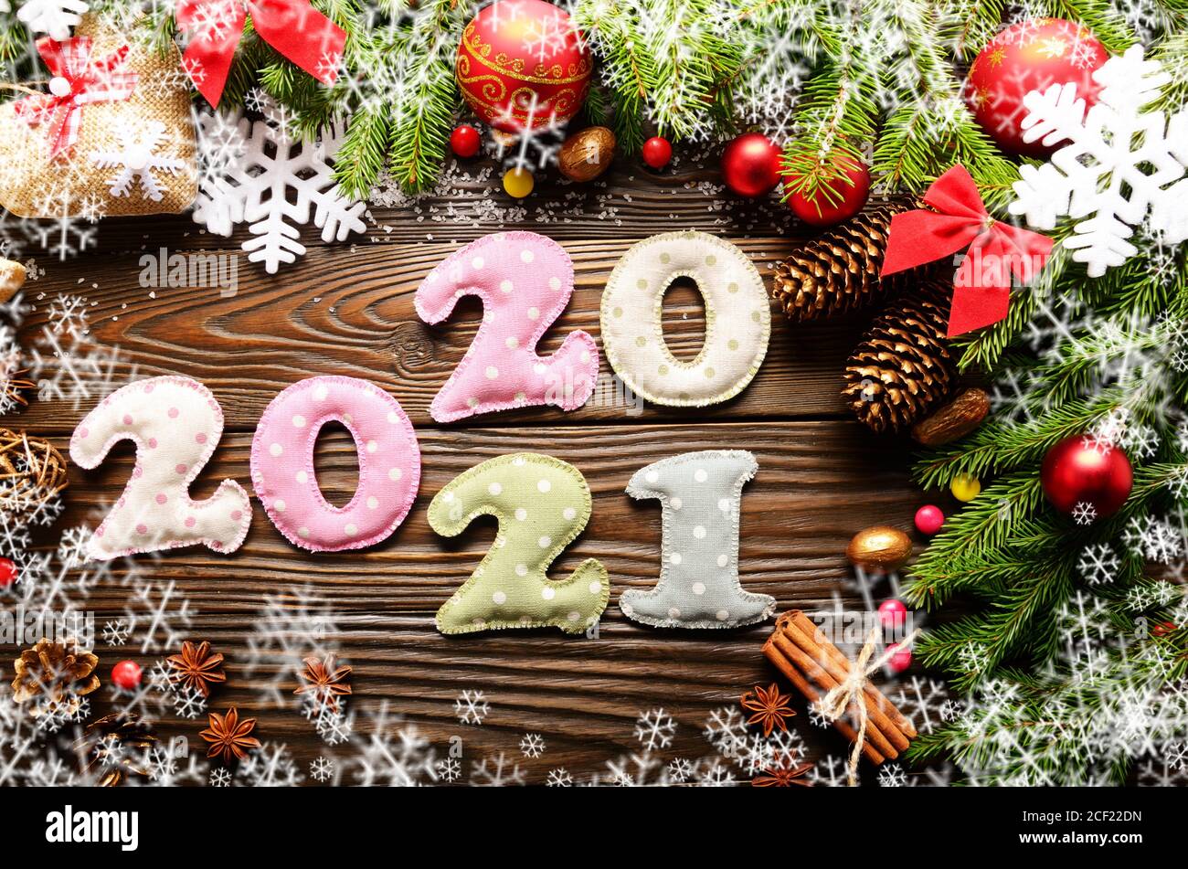 Colorful stitched digits 2020 2021 of polkadot fabric with Christmas decorations flat lay on wooden background. Stock Photo
