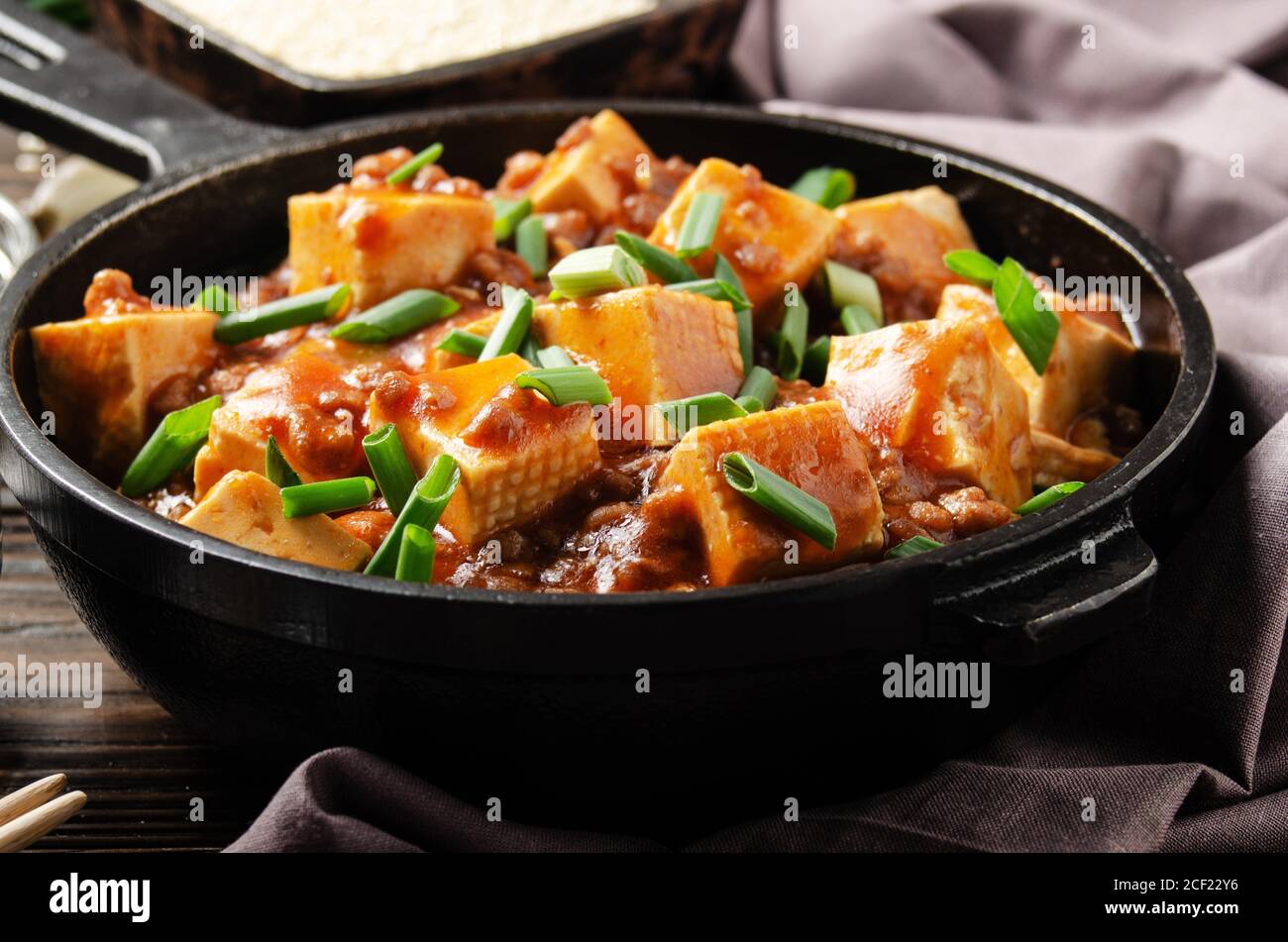 Mapo tofu in cast iron skillet with pork chopped chives soy sauce