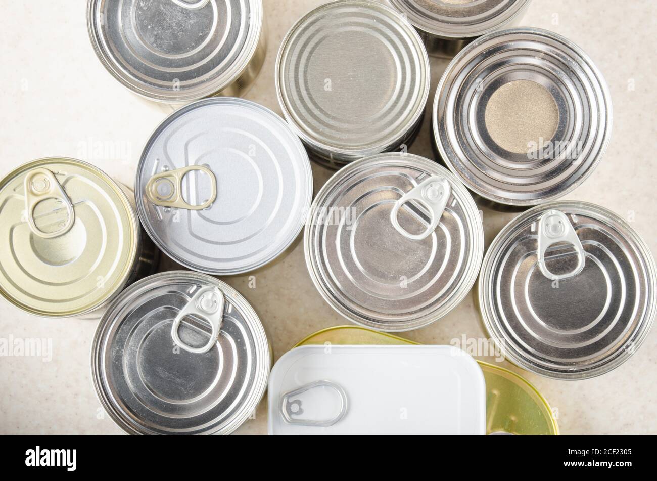 Flat lay view at various canned foods in tin cans on kitchen table, non