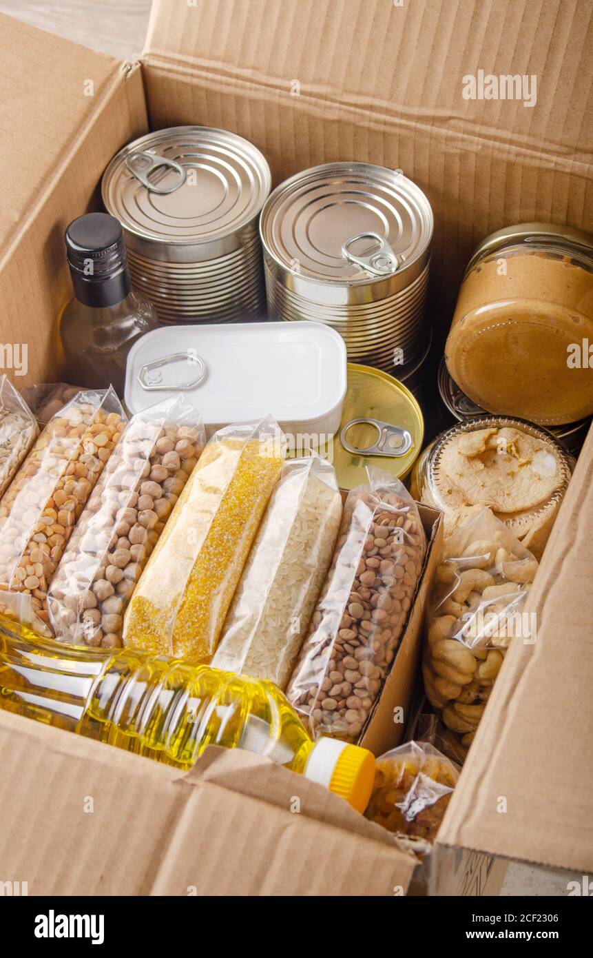 Set of uncooked foods in carton box prepared for disaster emergency conditions or giving away closeup view. Stock Photo