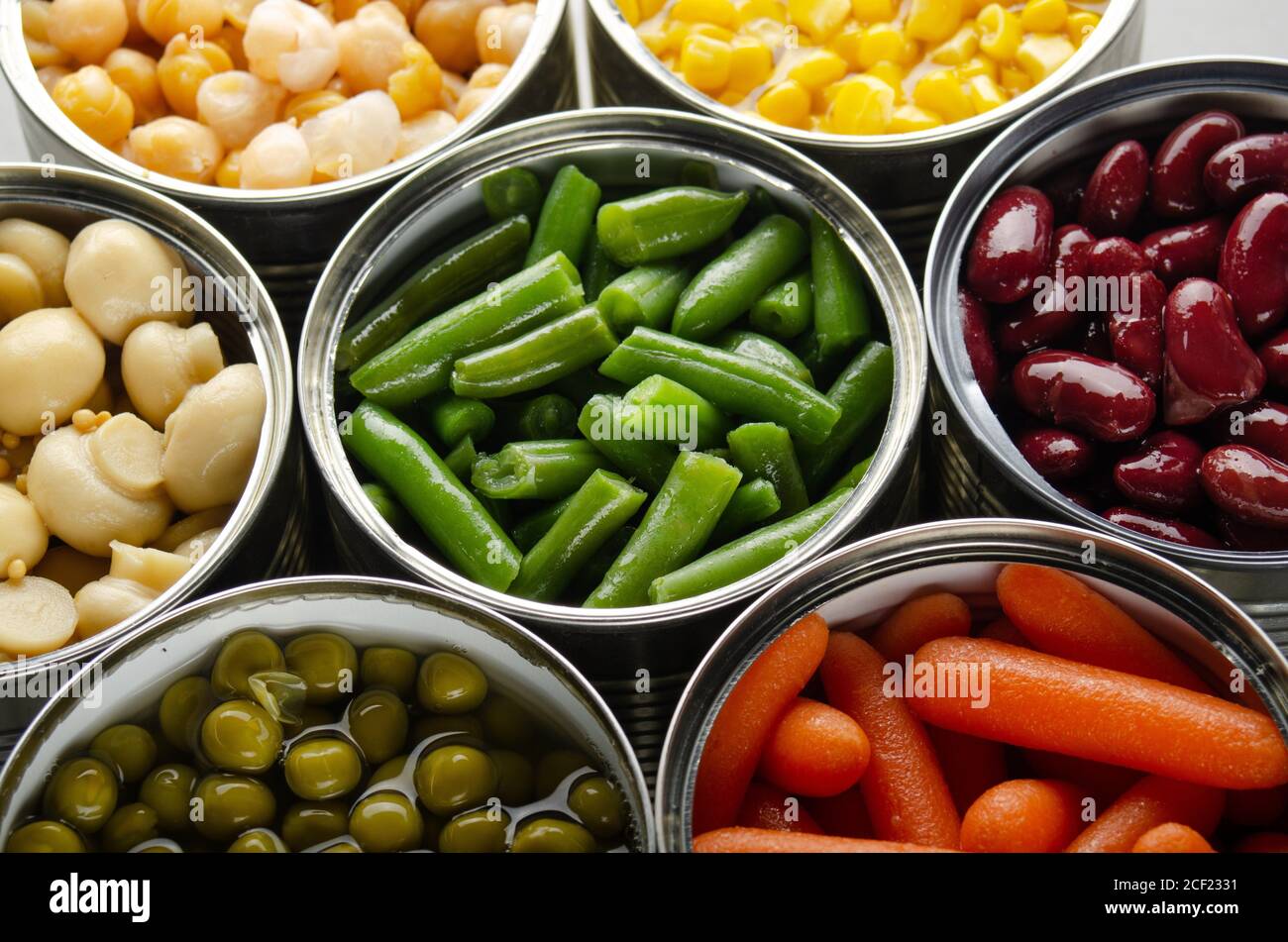 Canned vegetables in opened tin cans on kitchen table. Nonperishable