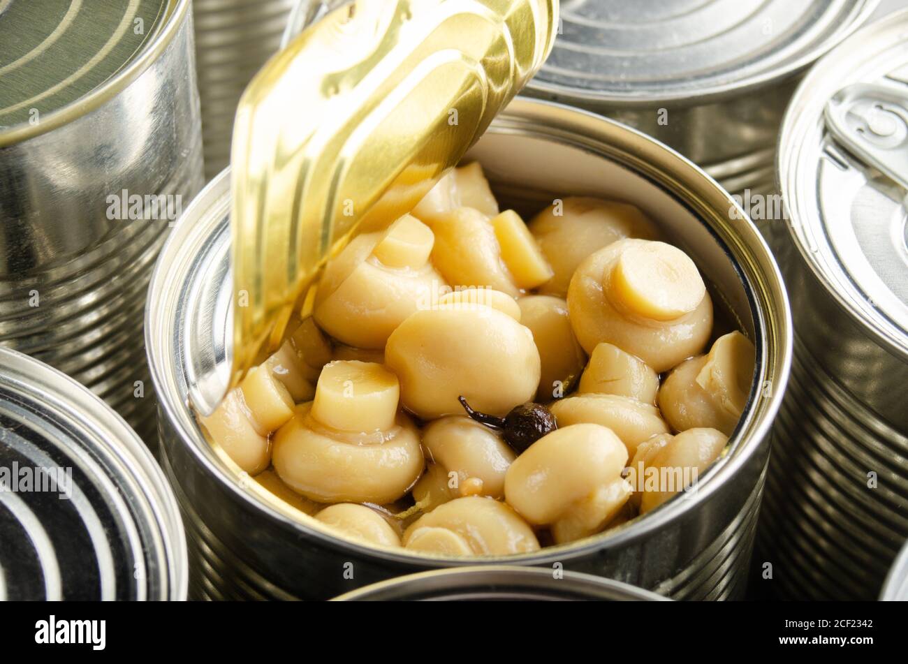 Canned button mushrooms in just opened tin can. Nonperishable food