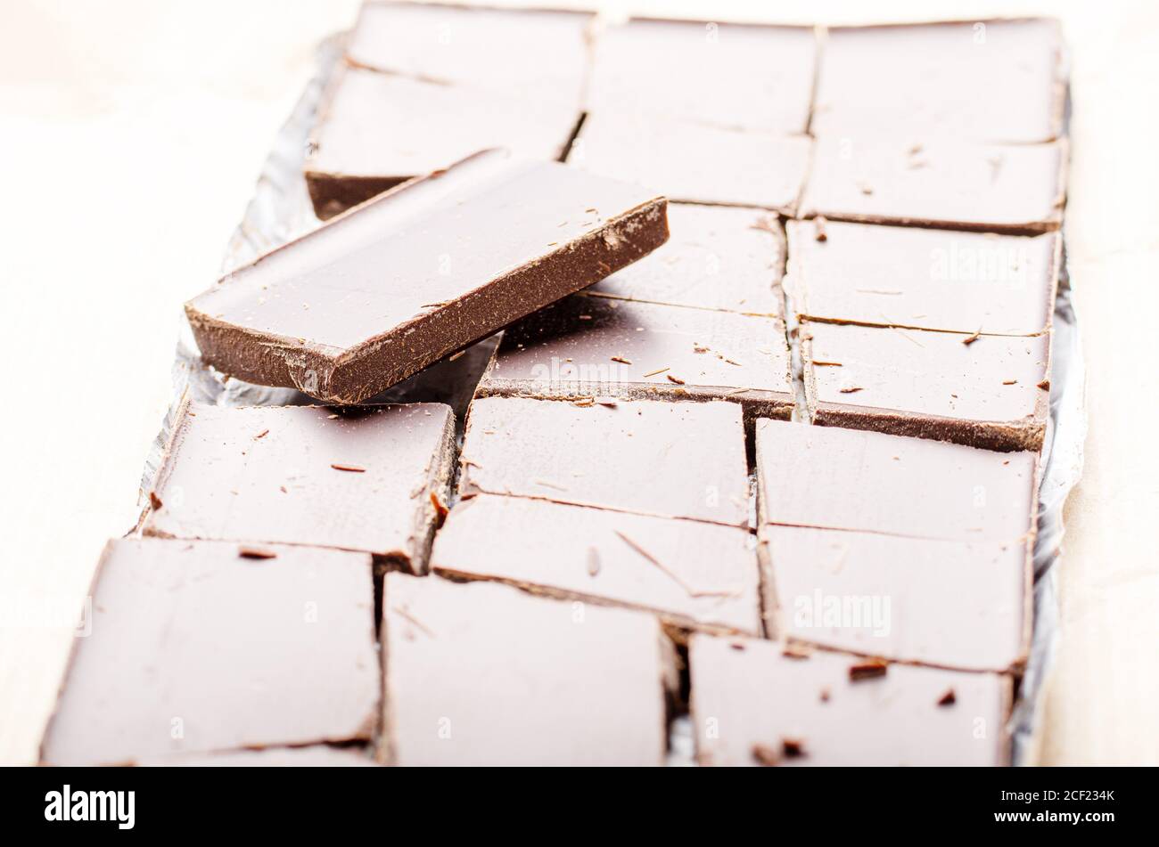 Dark Chocolate Bar Broken Into Pieces Laying In A Foil On Paper Wrap 
