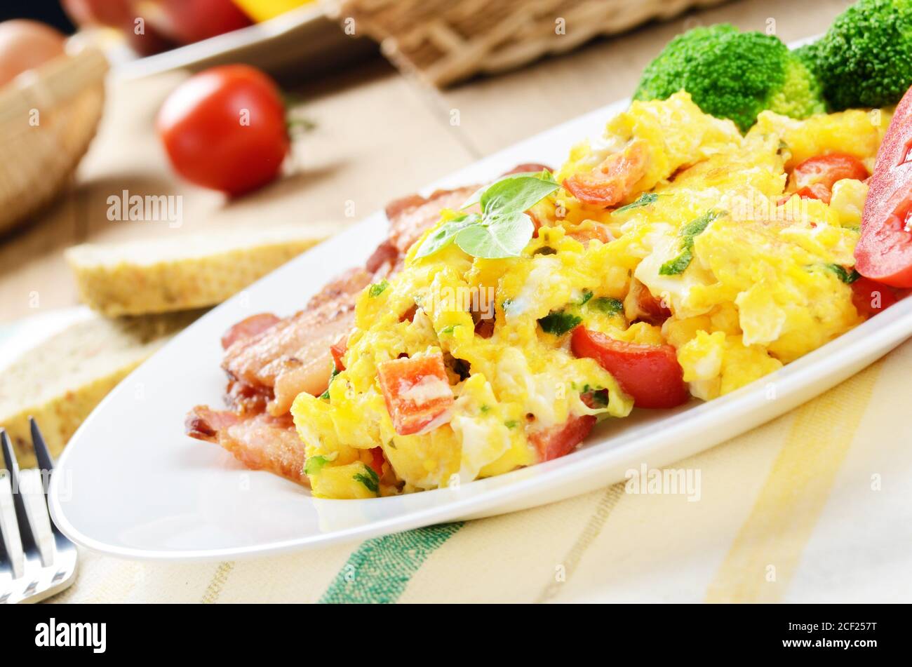 Omelet with vegetables, fried bacon and bread. Stock Photo