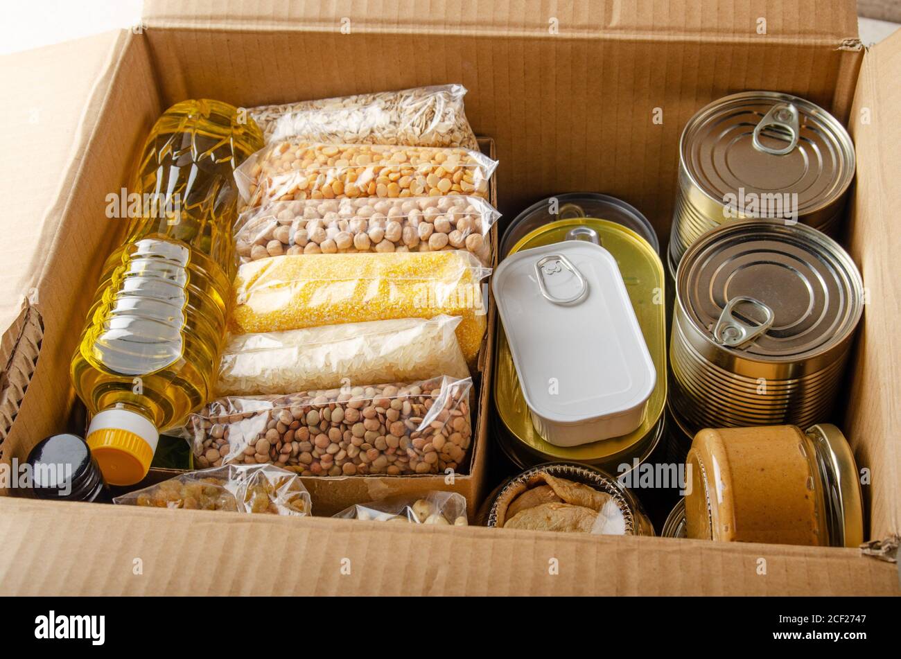 Set of uncooked foods in carton box prepared for disaster emergency conditions or giving away closeup view. Stock Photo