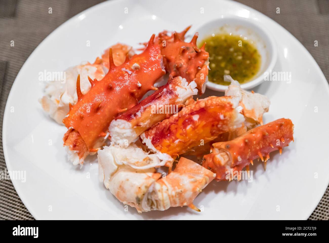 alaskan king crab and seafood on white dish with seafood sauce Stock