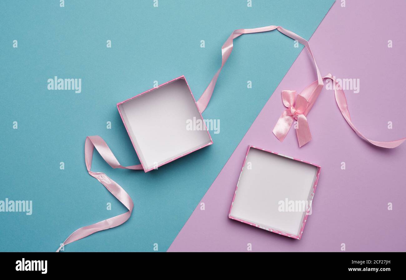 empty open cardboard box and pink ribbon with bow on blue lilac background,  flat lay Stock Photo - Alamy