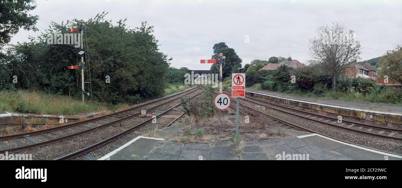 Helsby, UK - 21 July 2020: The speed limit sign, notices and semaphore signals at the end of the platform. Stock Photo
