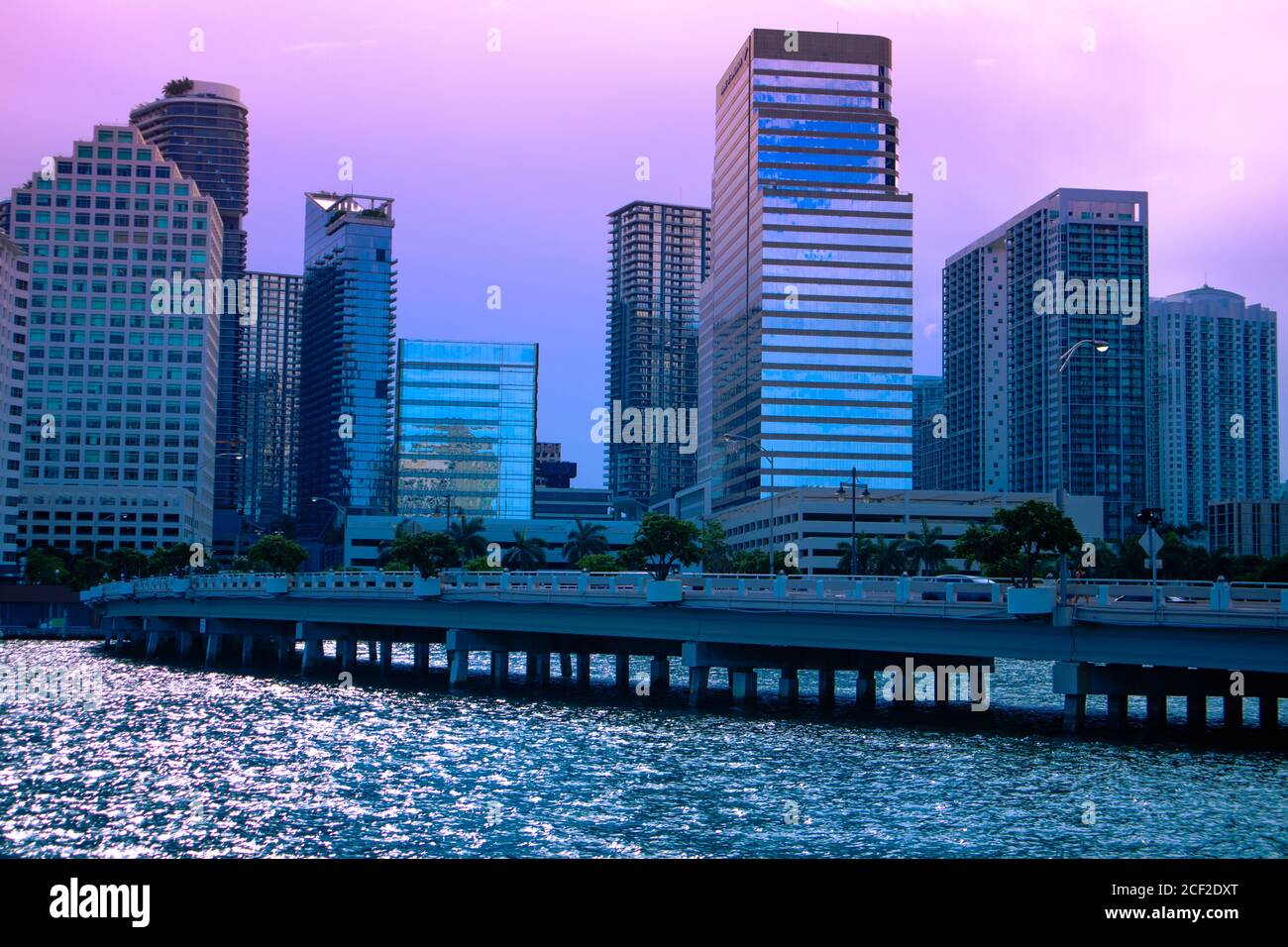 View of Brickell buildings next to the Brickell Key Drive bridge with the reflection of the sun setting in Miami, Florida, Reflection of sun setting o Stock Photo