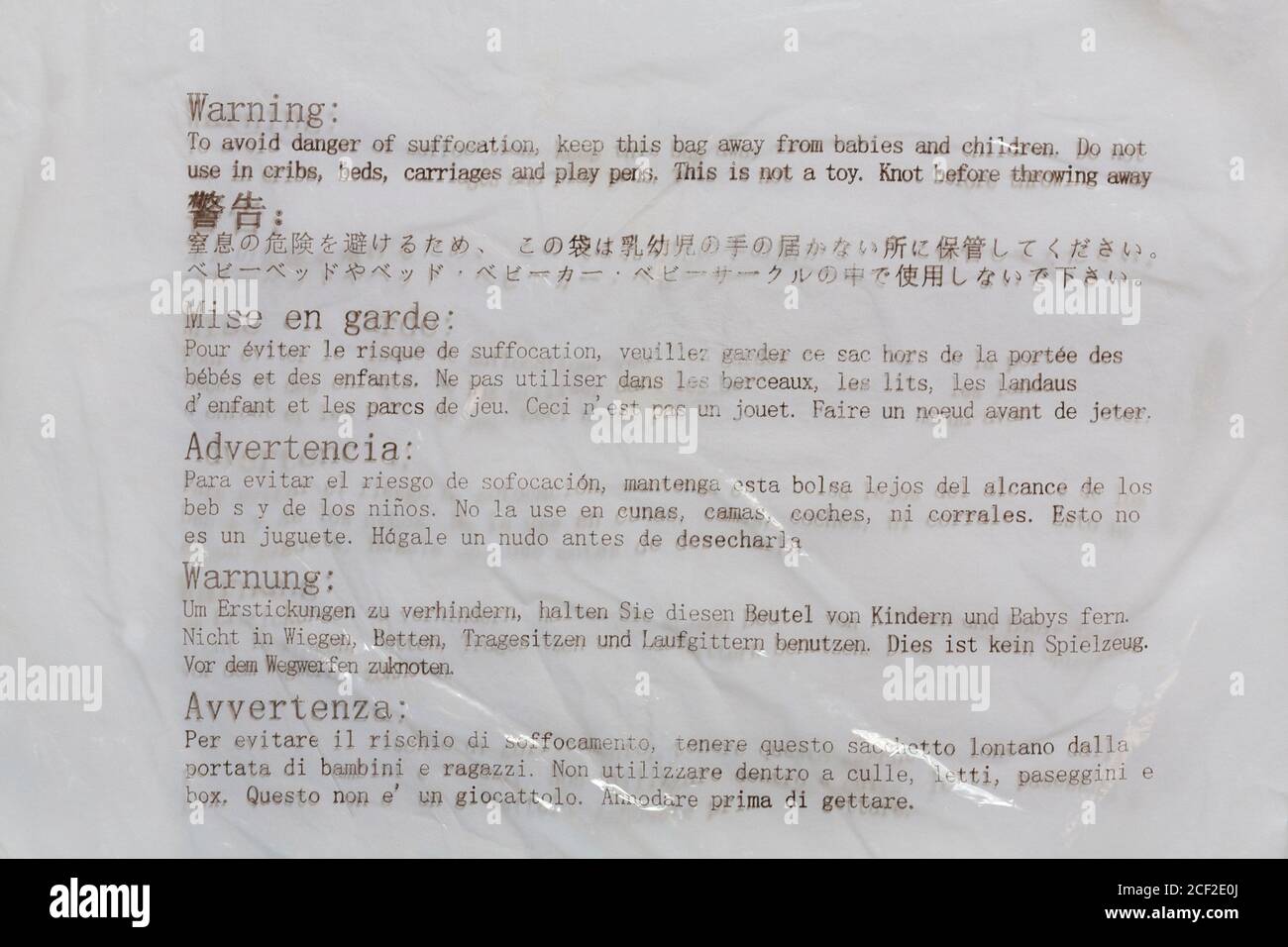 Warning to avoid danger of suffocation keep this bag away from babies and children - label on plastic bag wrapping Stock Photo