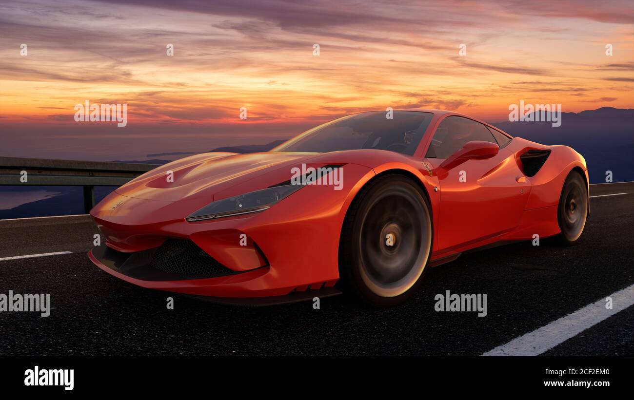 Ferrari F8 Tributo while driving fast on a road that runs through a beautiful landscape after sunset Stock Photo