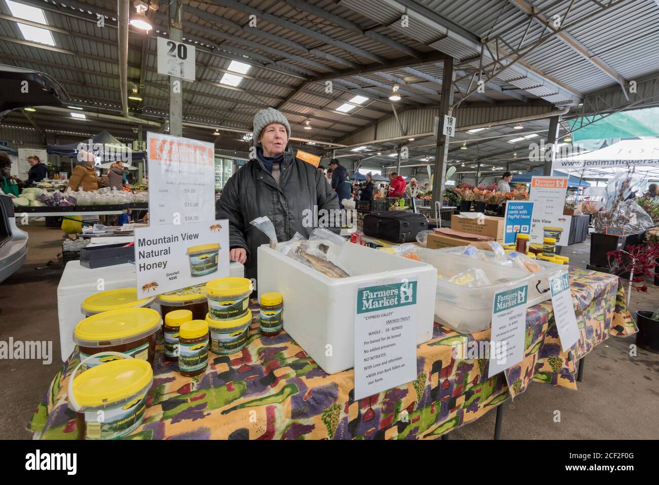 A woman selling local honey at the Australian Capital Region Farmers Market in Mitchell (Canberra) ACT, Australia Stock Photo