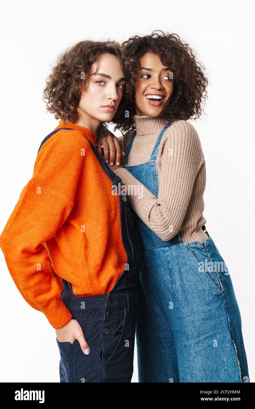 Portrait of nice multinational women in overalls looking at camera and ...