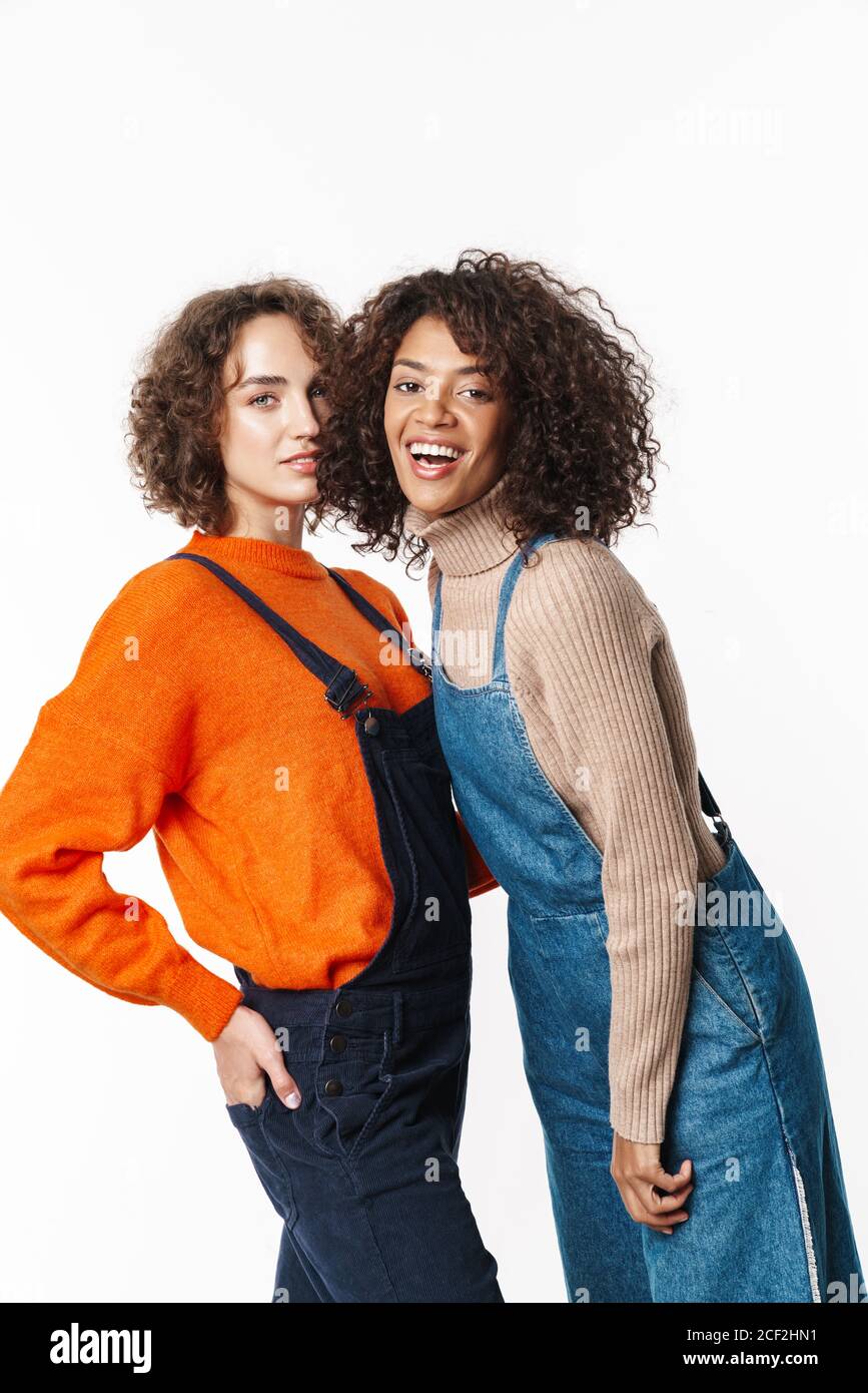 Portrait of smiling multinational women in overalls looking at camera ...