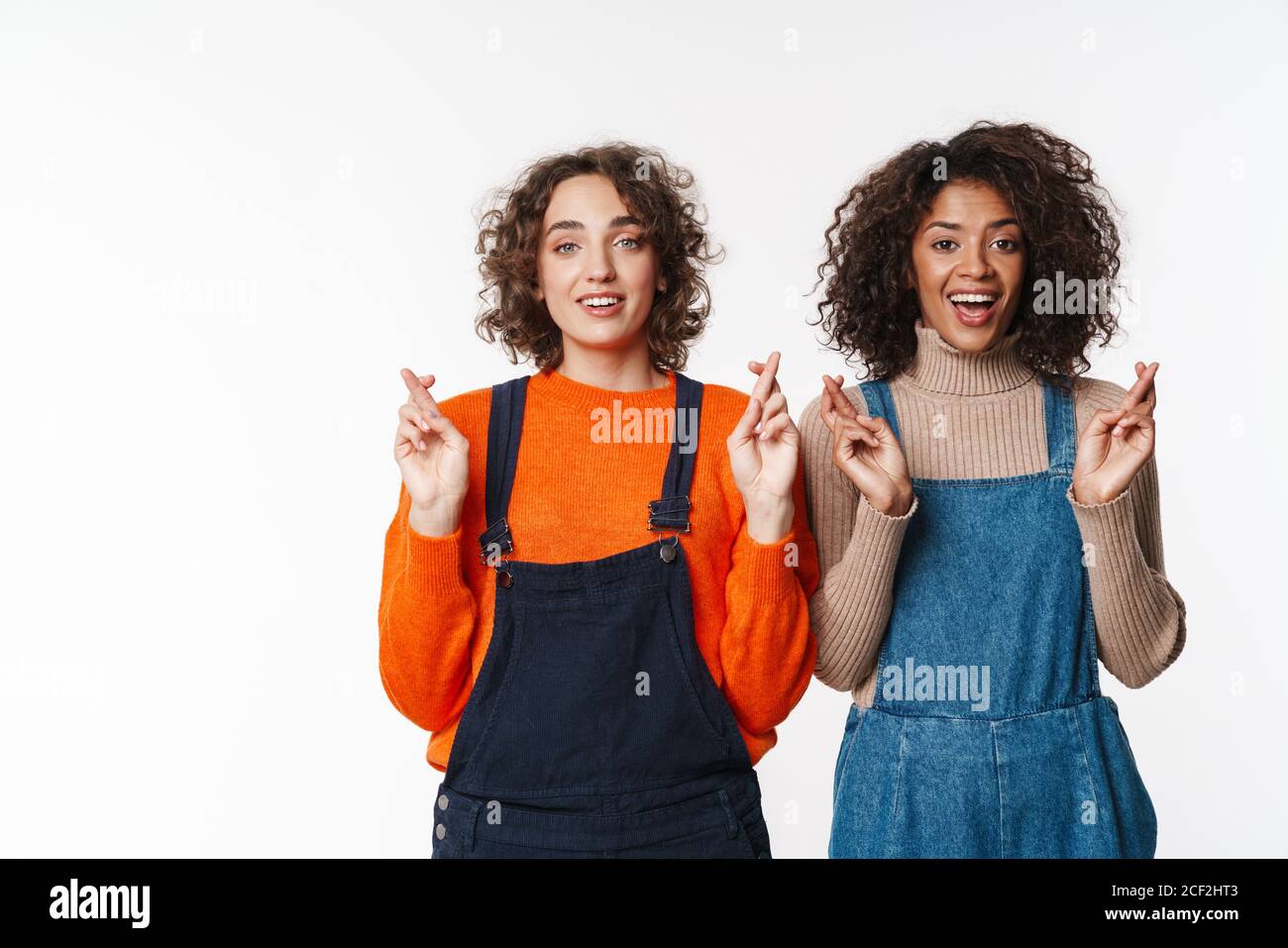 Portrait of happy multinational women in overalls looking at camera ...