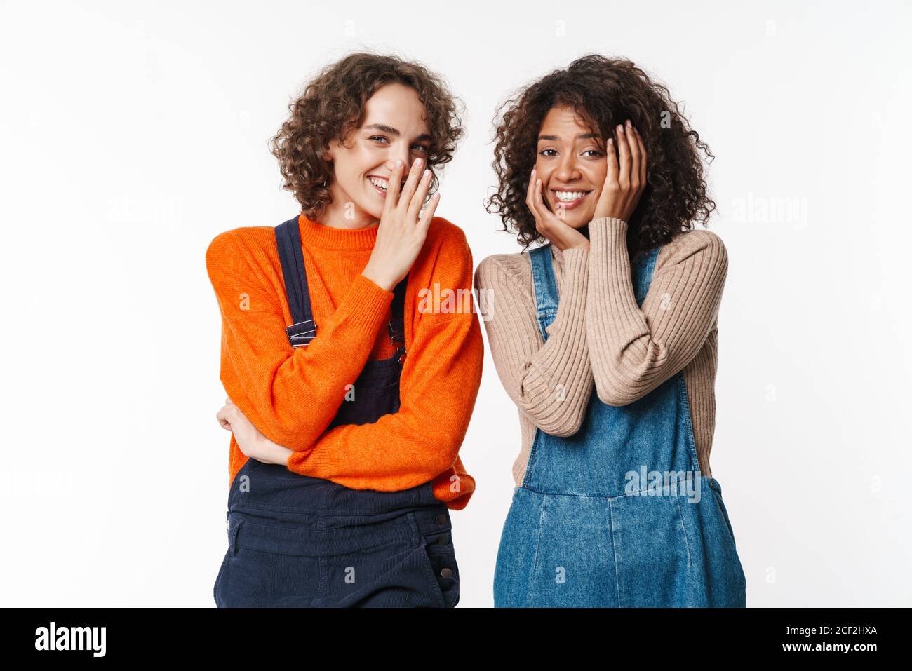 Portrait of happy multinational women in overalls smiling and looking ...