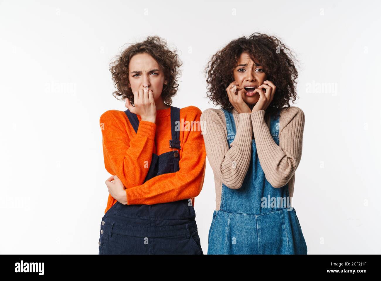 Portrait of frightened multinational women in overalls posing and ...