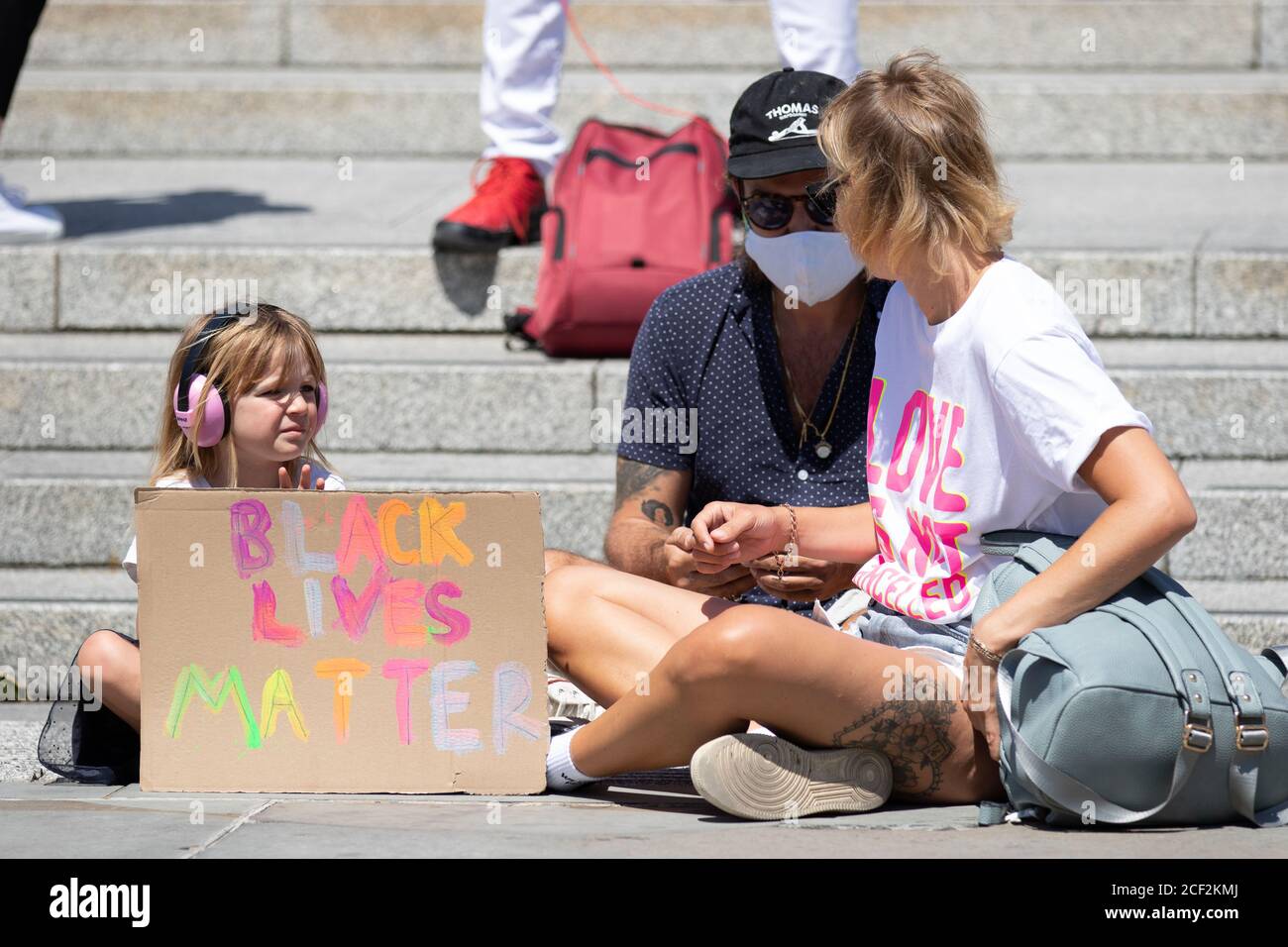 A young girl with her family holds a Black Lives Matter sign Stock Photo