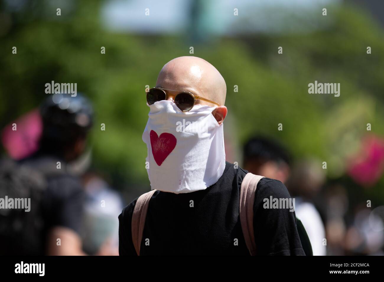 A bald white man wearing a white bandana with a red love heart symbol Stock Photo