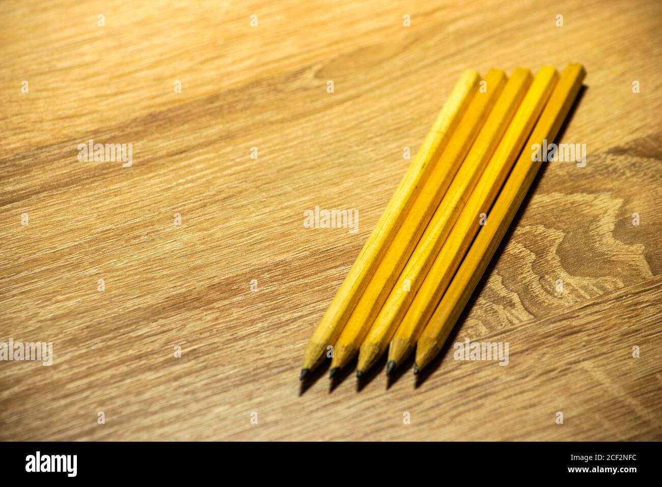 five pencils for drawing lie on a wooden table Stock Photo