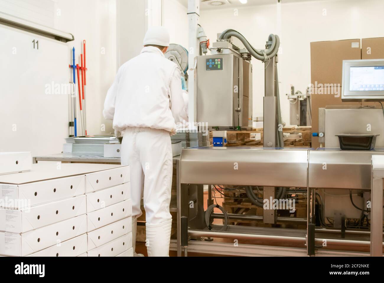 Packing goods in boxes in production. Packing paper box for food