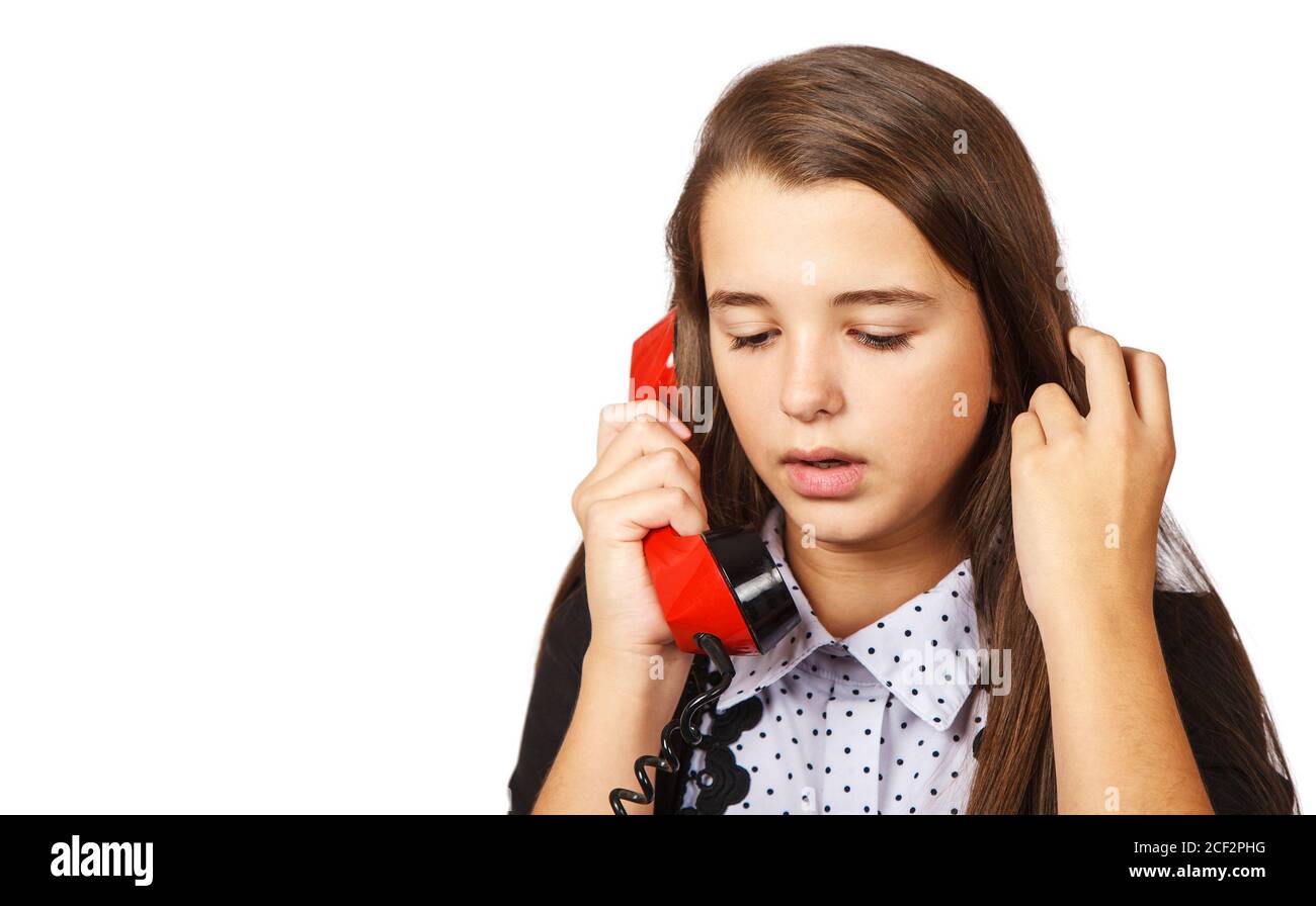teenage brunette girl talking on red retro telephone closeup on white background Stock Photo
