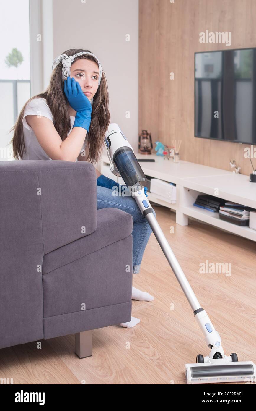 housekeeper .woman using vacuum cleaner in the living room.A young girl