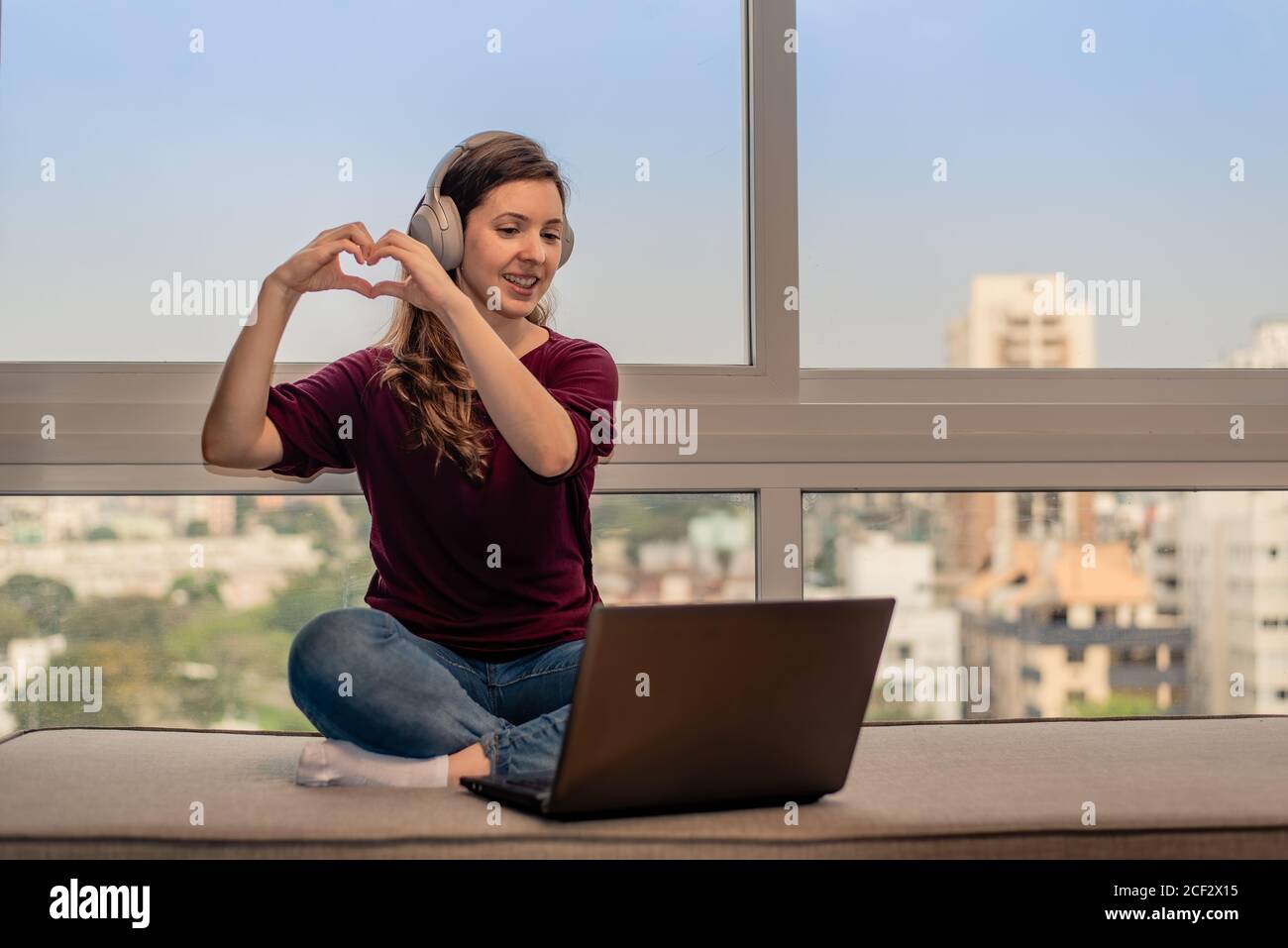 Woman making heart hands on online dating Stock Photo