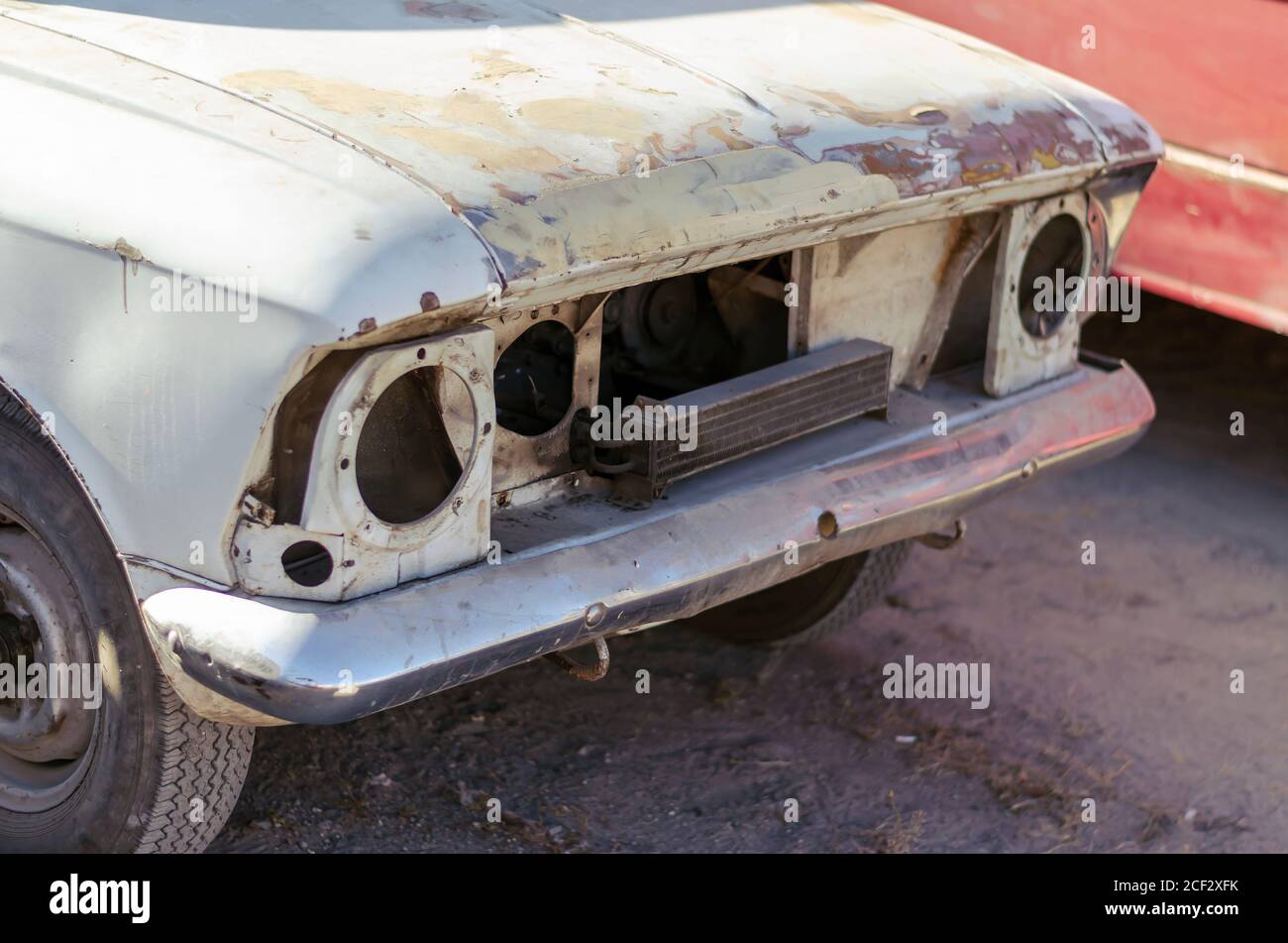 The front of an old abandoned car. Vintage car without headlights and