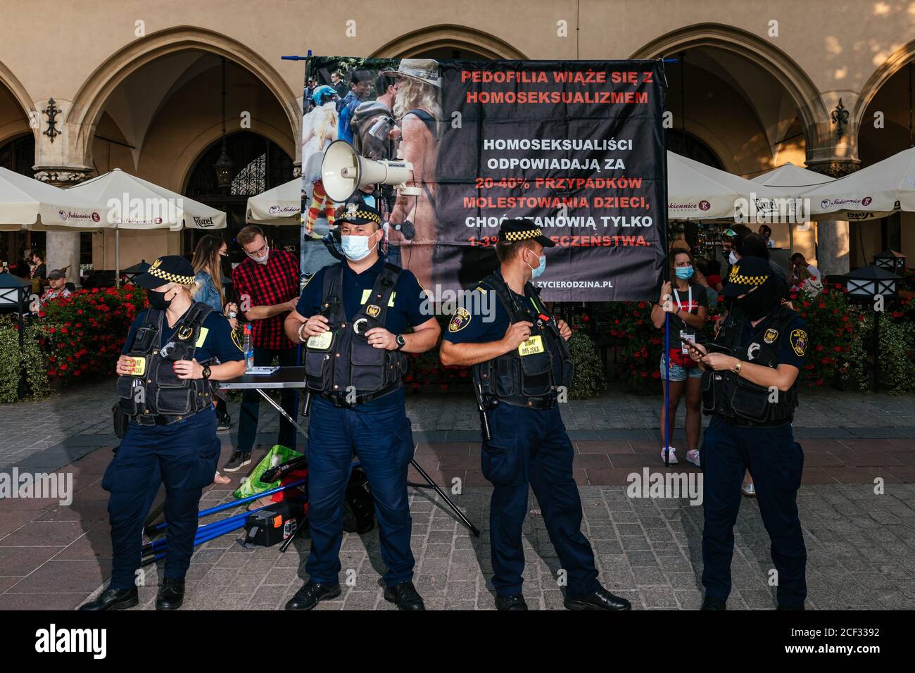 A group of municipal policeman separates participants of counterdemonstration holding disrespectful poster suggesting that homosexual people often are Stock Photo