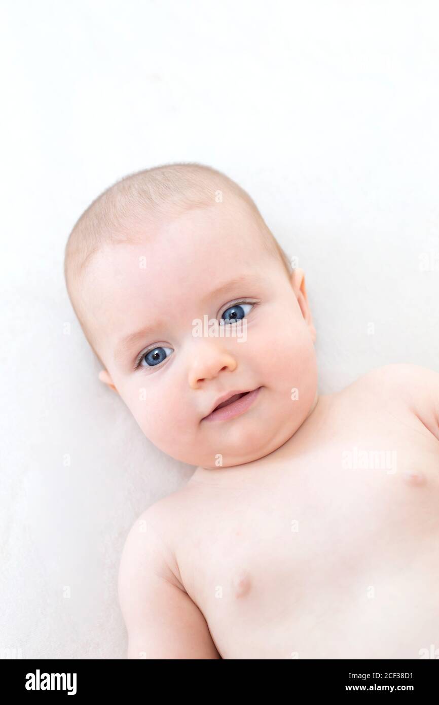 Cute adorable baby girl lying on the bed Stock Photo