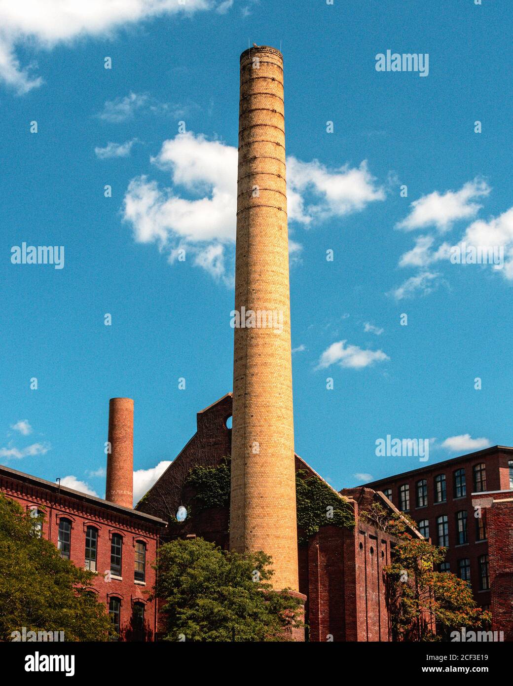 View of vintage smoke stacks and mill buildings from behind the Lowell
