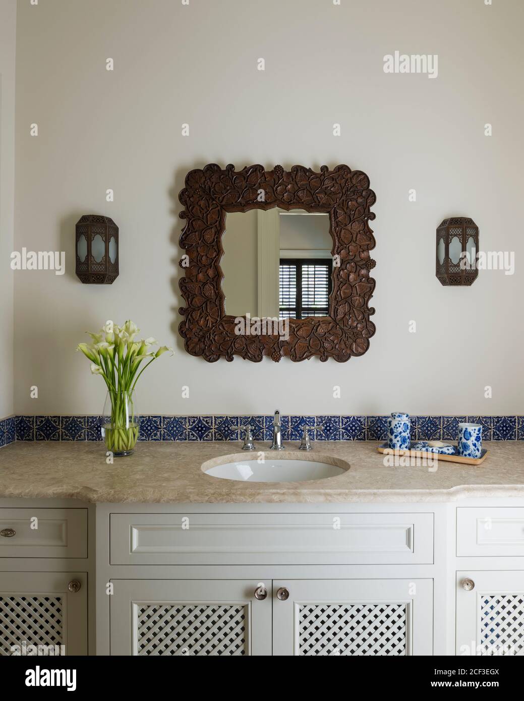 Carved mirror over bathroom sink Stock Photo