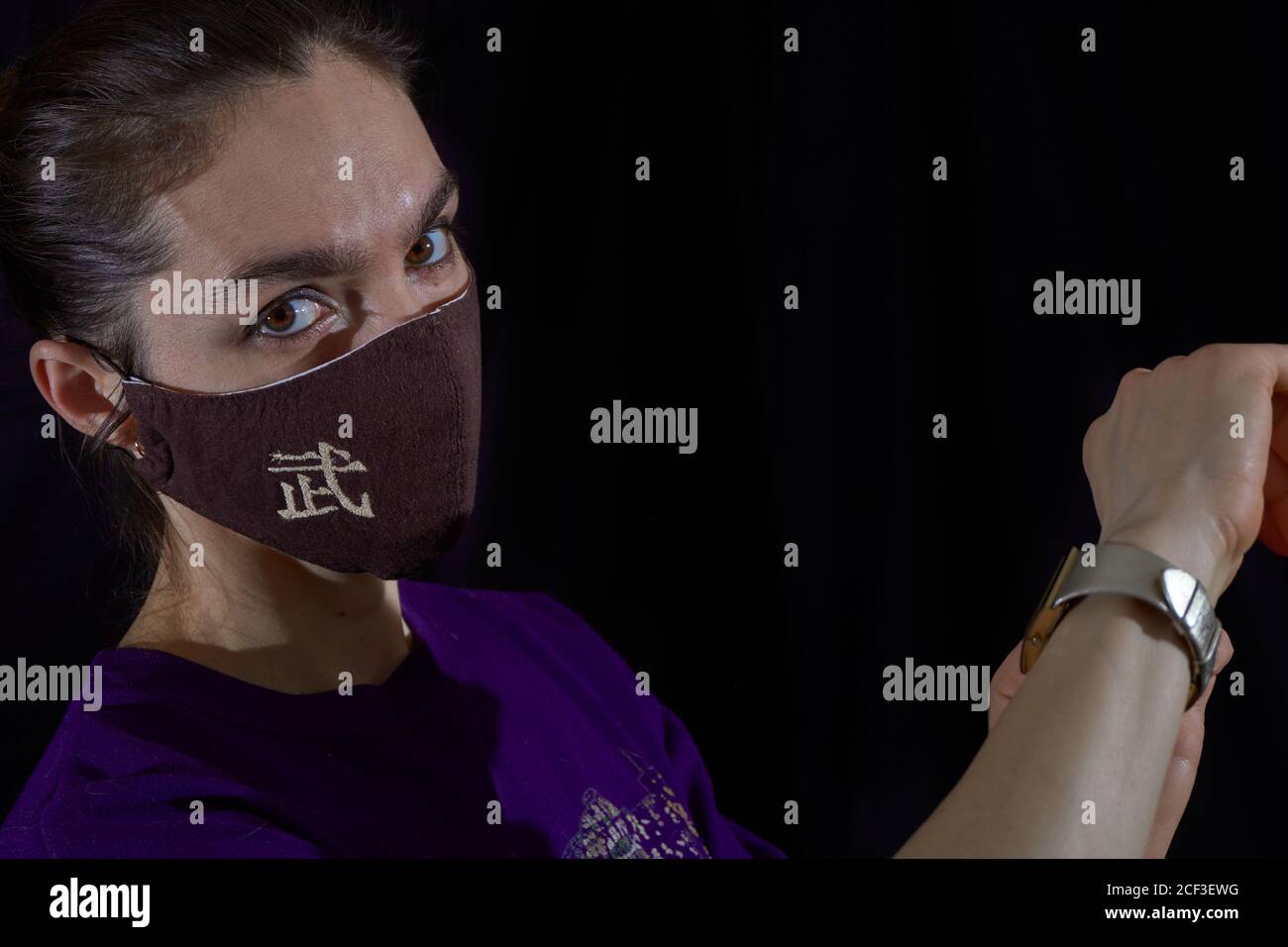 beautiful girl in mask looking on hand watch Stock Photo Alamy