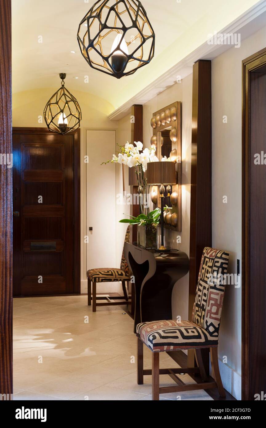 Chairs by table in hallway Stock Photo Alamy