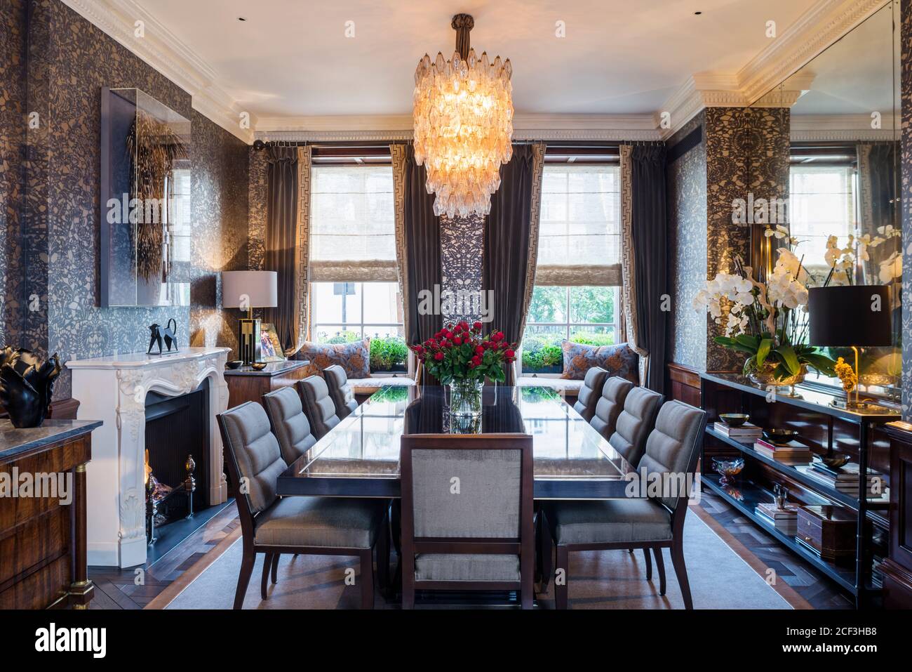 Lit chandelier in dark dining room Stock Photo